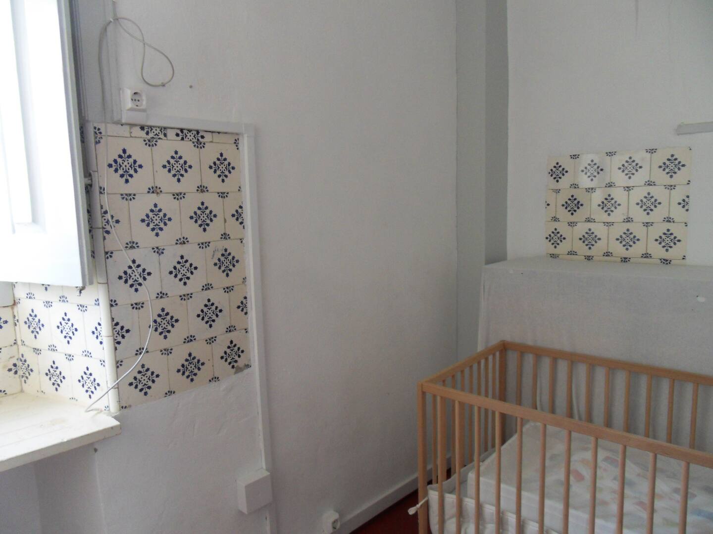 Tiled room upstairs, small double bed or a babybed.